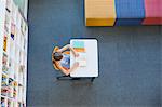 School girl reading a book in library