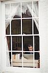 Man working on laptop at window