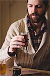 Attractive hipster man holding a shot