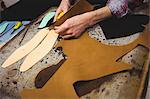 High angle view of cobbler cutting leather