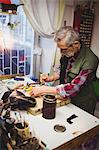 Portrait of cobbler putting wax on materials