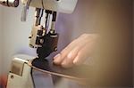 Close up of hands sewing a piece of leather