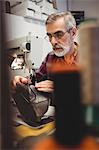 Focus on background of cobbler using sewing machine