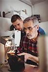 Portrait of young cobbler observing the work of his older