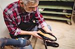 Overhead of cobbler checking a shoe