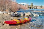 whitewater kayak with a paddle on a river shore  - Arkansas River at Big Bend near Poncha Springs, Colorado in winter scenery