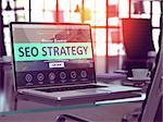SEO - Search Engine Optimization - Strategy Concept. Closeup Landing Page on Laptop Screen  on background of Comfortable Working Place in Modern Office. Blurred, Toned Image. 3D Render.