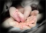 feets of newborn baby in mother hands