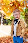 cool serious little boy enjoying time outdoors at beautiful autumn park