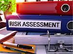 Risk Assessment - Blue Office Folder on Background of Working Table with Stationery and Laptop. Risk Assessment Business Concept on Blurred Background. Risk Assessment Toned Image. 3D.