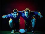 two caucasian rugby men players on colorful black background