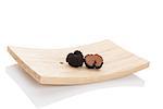 Truffles, rare mushrooms. Cut truffles on wooden plate isolated on white background. Luxurious culinary cooking ingredienets.