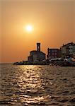 Silhouette of coastal city at sunset