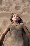 Sweden, Dalarna, Girl (10-11) lying in sand on beach