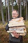 Sweden, Gastrikland, Ockelbo, Man carrying firewood