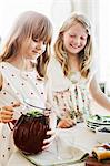 Sweden, Girls (8-9) pouring juice in dining room