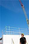 Sweden, Ostergotland, Linkoping, Construction worker standing on construction site, looking up