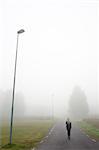 Sweden, Narke, Bjornhammaren, Woman walking along road in fog