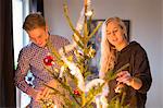 Sweden, Couple decorating Christmas tree