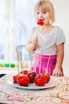 Girl (4-5) eating candied apple