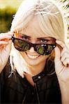 Sweden, Ostergotland, Smiling young woman in sunglasses