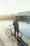 Sweden, Sodermanland, Stockholm, Sodermalm, Slussen, Mid adult man standing with fixed gear bike on jetty