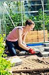Finland, Paijat-Hame, Mid adult woman paving in front of greenhouse