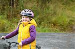 Finland, Keski-Suomi, Jyvaskyla, Smiling girl (6-7) siting on bicycle