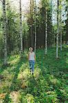 Finland, Mellersta Finland, Jyvaskyla, Saakoski, Woman walking across forest glade