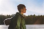 Finland, Esbo, Kvarntrask, Portrait of young man on shore of forest lake