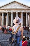 Young woman standing back, looks at the Roman Pantheon
