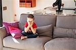 Boy laughing, sitting on a couch
