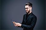 Portrait of a smiling young businessman holding a touch pad in his hands