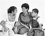 1970s AFRICAN AMERICAN MOTHER DAUGHTER SON FAMILY SITTING PORTRAIT