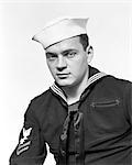 1940s PORTRAIT SERIOUS AMERICAN SAILOR WEARING NAVY UNIFORM LOOKING AT CAMERA