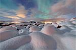 The pink light and the aurora borealis (Northern Lights) illuminate the snowy landscape on a starry night Stronstad, Lofoten Islands, Arctic, Norway Scandinavia, Europe