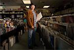 Portrait of mature man in record shop, holding records