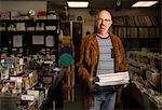 Portrait of mature man in record shop, holding records