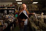 Mature man in record shop, filing records