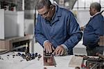 Carpenter using chisel in wood workshop