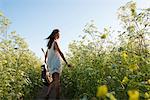 Woman with guitar in field of wildflowers