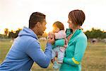 Couple playing with baby in park