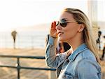 Young blond woman on sunlit pier, Santa Monica, California, USA