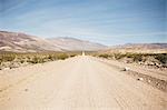 Straight dirt track road in desert landscape, Olancha, California, USA