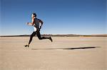 Man training, running on dry lake bed, El Mirage, California, USA