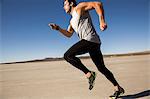 Man training, running on dry lake bed, El Mirage, California, USA