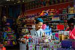 Teenage boy and girl browsing in candy shop, Brooklyn, USA