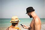 Couple on beach with cell phone