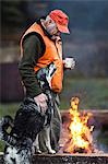 Man with dog at campfire