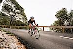 Woman cycling on country road